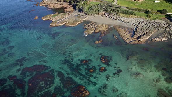 Circle Aerial Over Goat Island With Gentle Smooth Swell Splashing On Rocky Shore, New Zealand