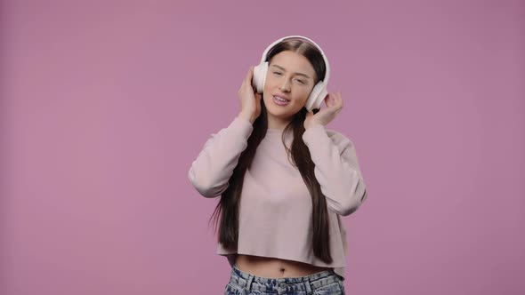 Portrait of a Beauty Model Enjoying Music in Big Wireless White Headphones