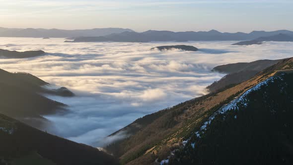 Foggy Morning above Clouds in Mountains