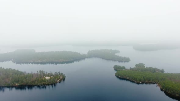 Aerial shot of islands with forest, calm lake and small settlement in Willard Lake, Ontario, Canada