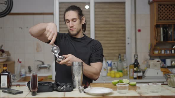 Focused Barman Squeezing Limes for Cocktail Juice in Kitchen Countertop