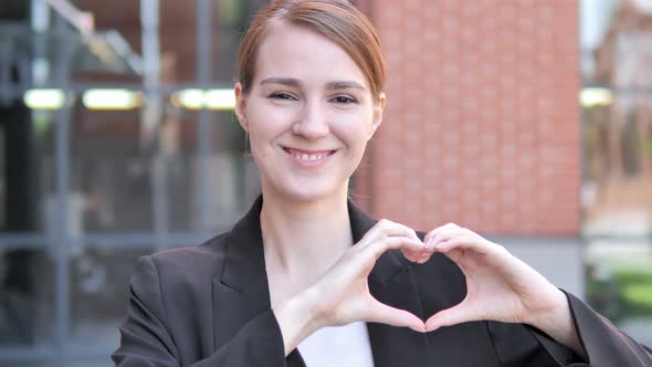 Handmade Heart by Young Businessman Standing Outdoor