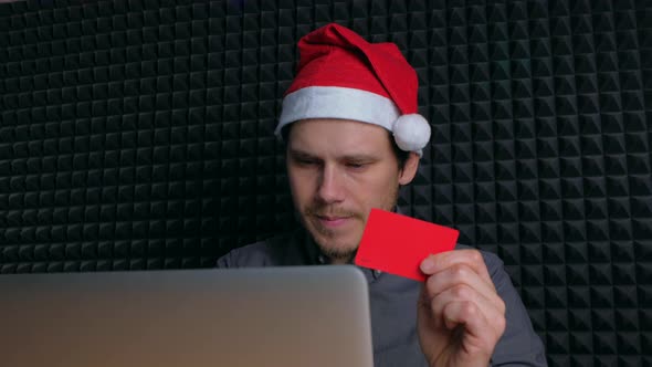 Person Holding Credit Card and Using Laptop in Home at Night