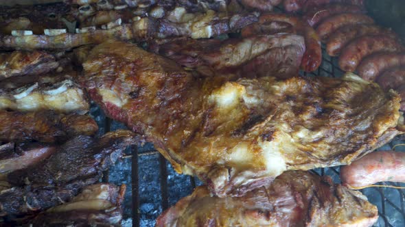 Close up shot of crispy and roasted pieces of chicken and beef in Argentinian asado