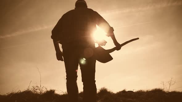 A Man Gardener with a Shovel of the Earth and the Roots of the Fruit Tree