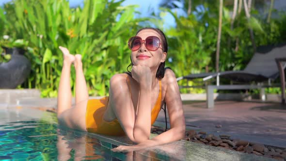 Young asian woman enjoy around outdoor swimming pool for leisure