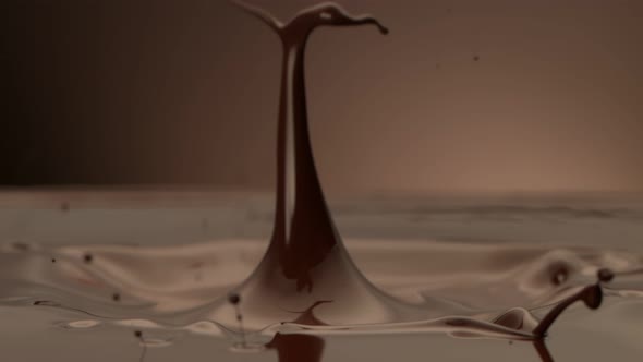 Super Slow Motion Detail Shot of Melted Chocolate Crown Splash on Brown Background at 1000 Fps