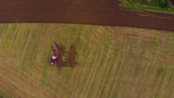 red tractor working on green field