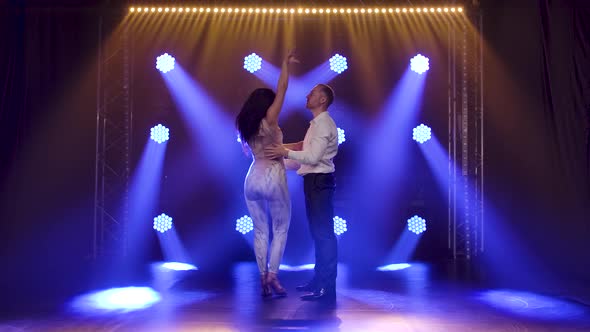 Young Couple Dancing Latin Music, Bachata, Merengue, Salsa, Shot in a Dark Studio with Neon Lights