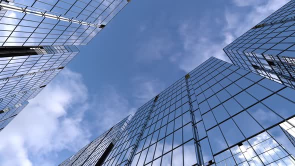 business towers, camera animation among high-rise buildings with blue reflective sky.