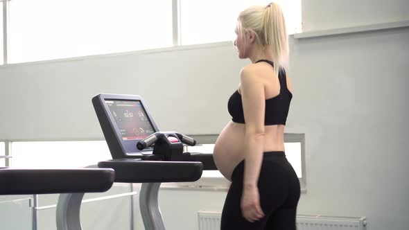 Pregnant Woman Training Treadmill Machine in Gym Cardio Exercises on Running Simulator