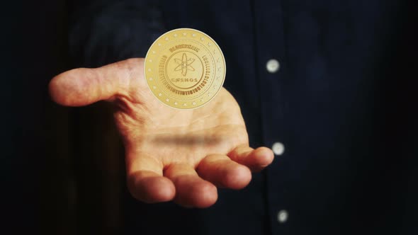 Cosmos atom cryptocurrency golden 3d coin over hand