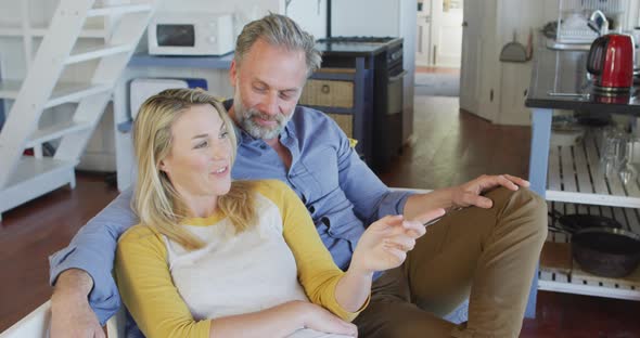 Happy caucasian mature couple having fun and sitting in in living room