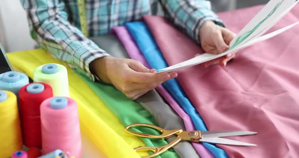 Designer Stylist Looks at Sketches of Clothes on Paper