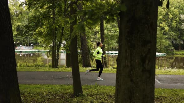 Runner Woman Runs in Park on Asphalt Road