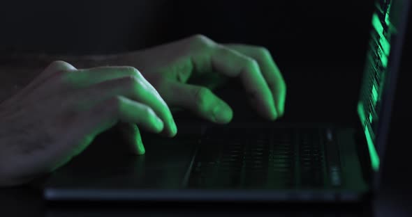 Hacker hands typing on a keyboard, close up view