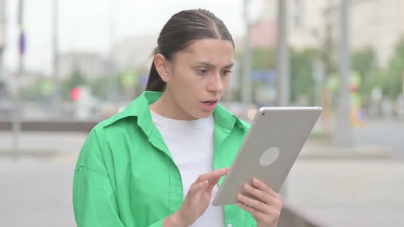 Upset Hispanic Woman Reacting to Loss on Tablet Outdoor