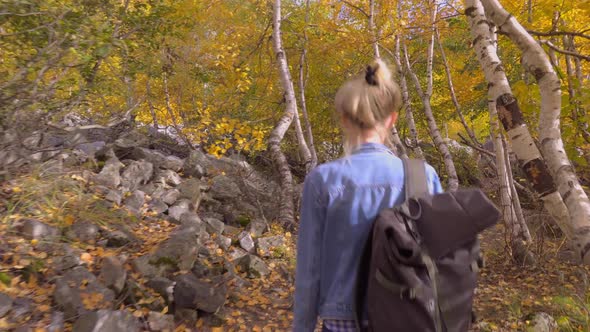 A young beautiful slender woman alone in the mountains.