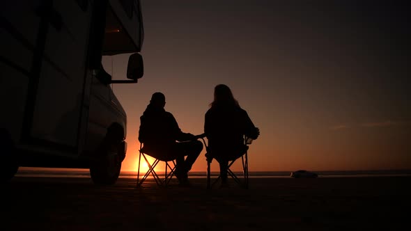 Couple Relaxing Next to Their RV Motorhome Camper Van