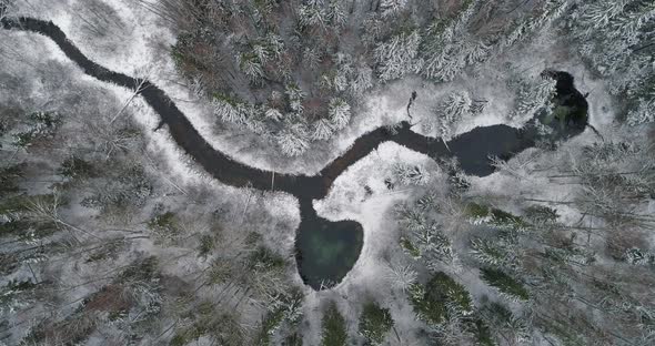 Heart Shape Spring Water Lake Connected to River in Snowy Forest Aerial View