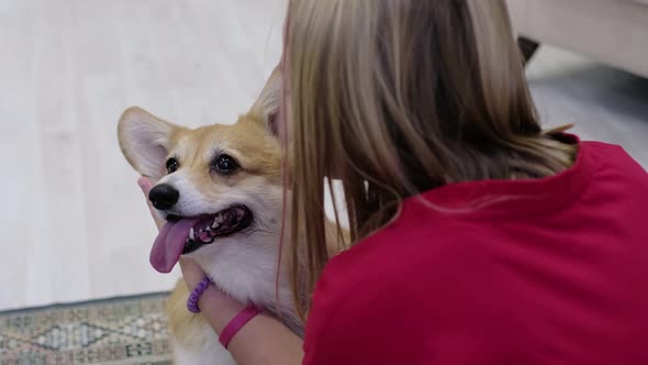 Young Teen Girl Hugging Corgi Dog with Love