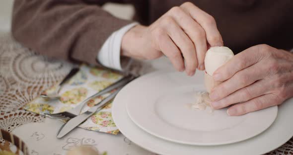 Old Man Peeling Egg on Plate