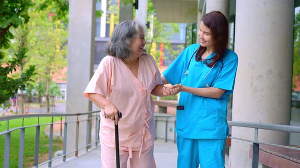 Doctor help old elderly Asian woman uses a walker and walking for physical therapy in the hospital.