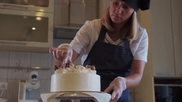 Woman Chef Decorating White Handmade Cake with Chocolate on the Serving Plate