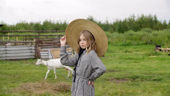 Adorable Teenage Girl in Hat Posing on Rural Farm