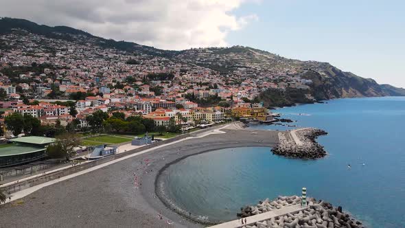 Aerial view of the city landscape and tourists lying on the beach in Funchal, Madeira, Portugal
