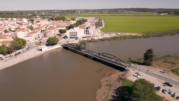 Orbiting shot around rodoviaria bridge with traffics crossing sado river and parish townscape.