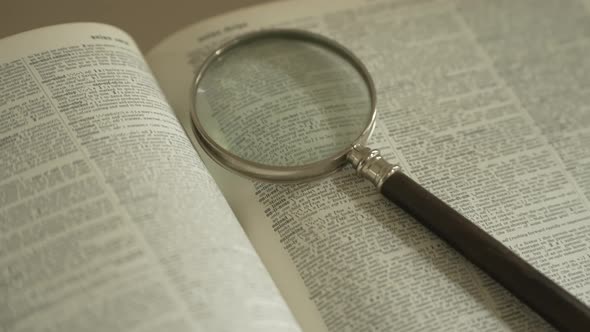 Magnifying glass on large opened book