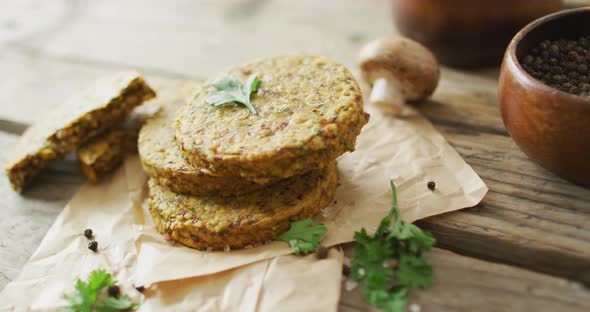 Video of fresh leaves and vegetarian burgers over wooden background