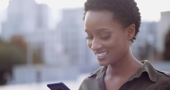 Close Up of Young Beautiful African Ethnic Woman Holding Phone in Her Hands, Smiling Looking at