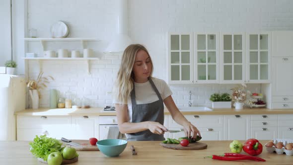 Young Funny Woman Dancing and Singing with Ladle While Having Leisure Time in the Kitchen at Home