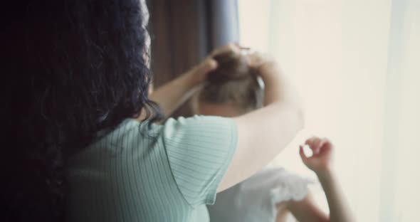 Mother Combs Her Daughter's Hair