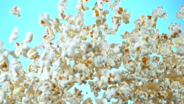 Super Slow Motion Shot of Popcorn on Blue Background After Being Exploded at 1000Fps.
