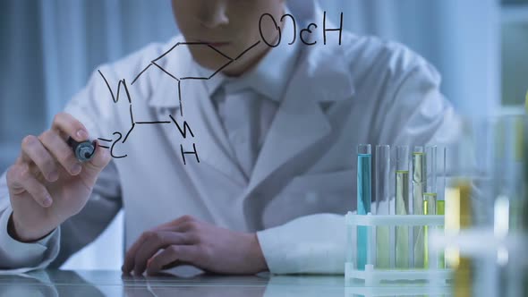 Scientist Mixing Substances in Test Tubes According to Formula Written on Glass