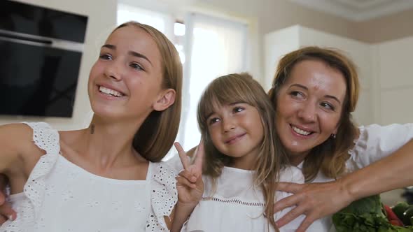 Portrait of a Happy Family Who Makes a Selfie, Photographed on a Smartphone  in Kitchen