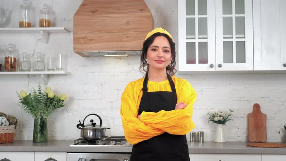 Portrait Smiling Housewife Looking Camera with Crossed Hands in Home Kitchen