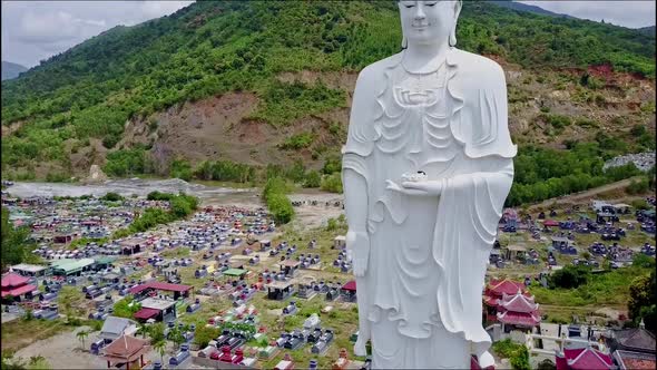 Flycam Moves From Head of Buddha Statue To Feet Against Hill