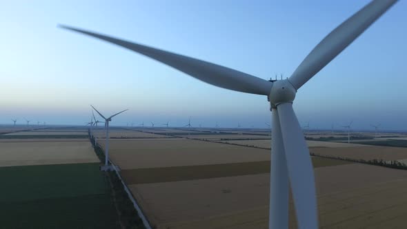 Wind Turbines in Fields Near the Sea Driven with the Sea Breeze, Aerial Survey, Close Up
