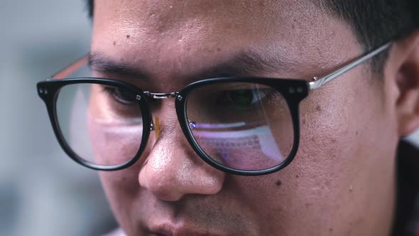 Close up face Asian man wearing glasses working seriously