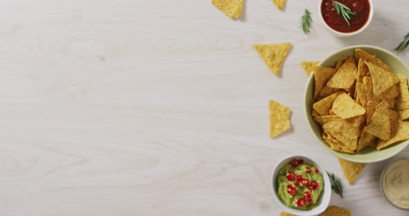 Video of tortilla chips, guacamole and salsa dip on a wooden surface