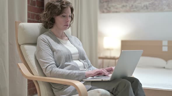 Old Woman Using Laptop on Sofa 