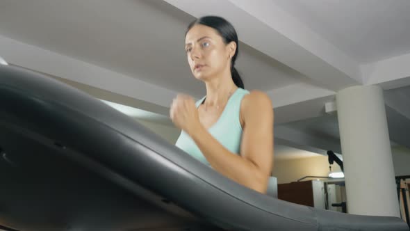 Young Athletic Woman on a Treadmill at the Gym