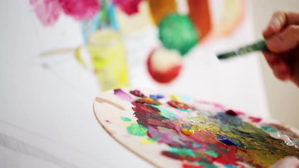 Artist with Palette and Brush Painting at Studio