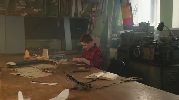 A Boy Decorates His Airplane Model with Stickers