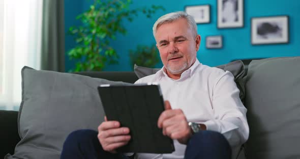 A Closeup of a Grandfather Using a Tablet Computer