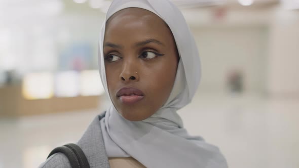 Thoughtful Black Lady with Hijab on Head in Shopping Center